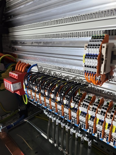 Detalj precizno povezanih provodnika i rednih stezaljki u industrijskom elektro ormanu